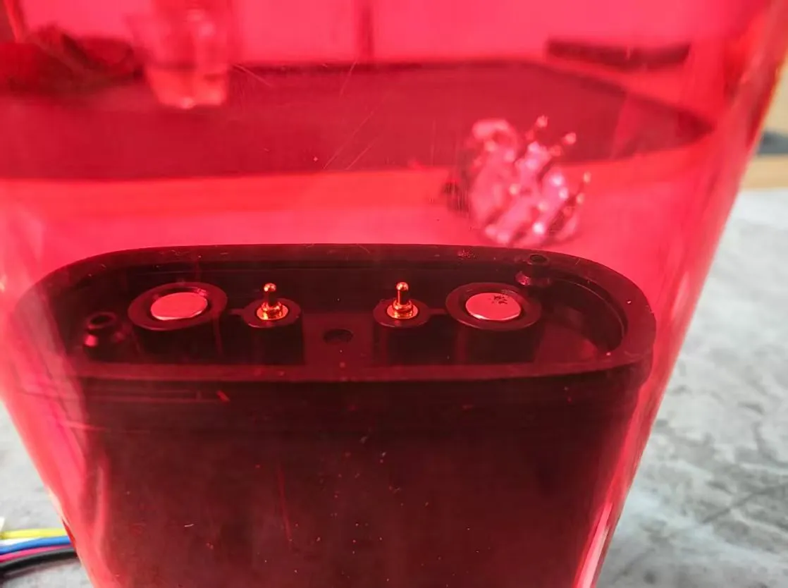 Black e-cigarette pod base showing four electrode contacts